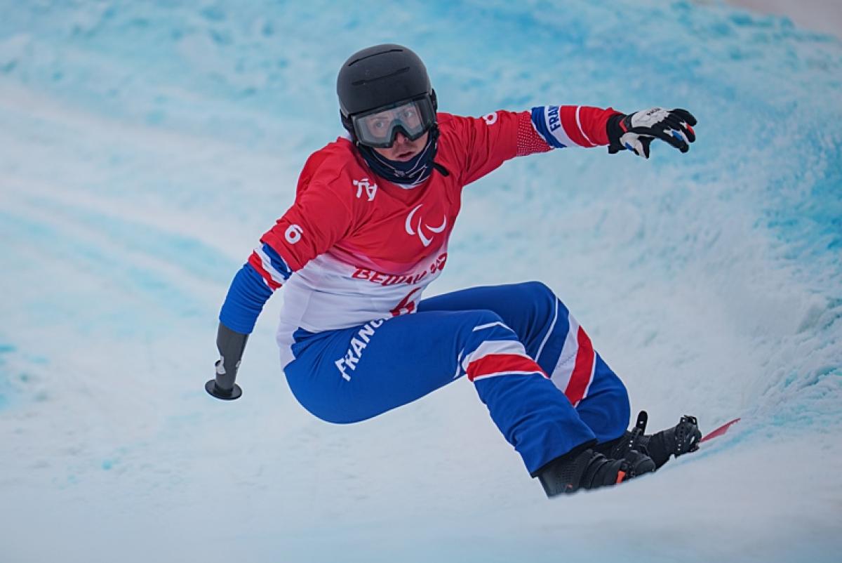 A male Para snowboard athlete competes at the Beijing 2022 Paralympic Winter Games